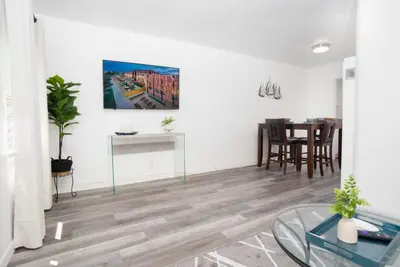 a living room with a table and a painting on the wall at Seaside Point Loma Home with Outdoor Patio in San Diego