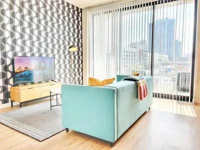 a living room with a blue couch and a tv at The Traveler's Getaway in San Diego