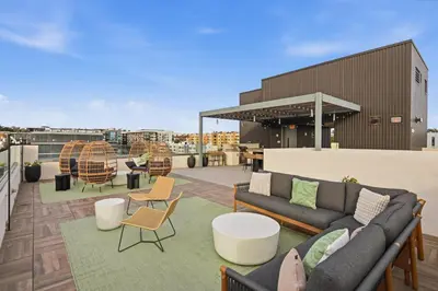 a rooftop patio with a couch and tables and chairs at The Traveler's Getaway in San Diego
