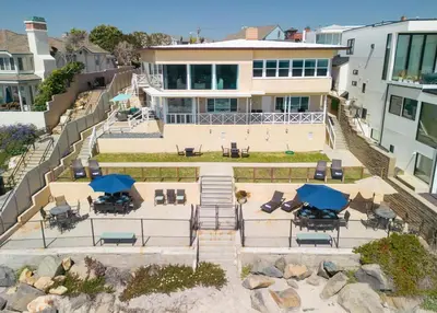 an aerial view of a house with chairs and umbrellas at CB-2445D - Located on the Sand- Casa De Los Suenos in Carlsbad