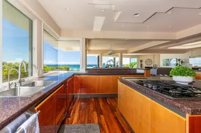 a kitchen with wooden cabinets and a large window at Unbeatable Location - Steps to Moonlight Beach in Encinitas