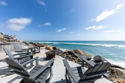 a row of chaise lounge chairs on the beach at Stunning Oceanfront Home - Incredible Views in Oceanside