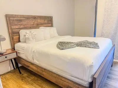 a white bed with a bow tie on it at Charming 2nd Ave Lofts in Downtown San Diego with Parking in San Diego