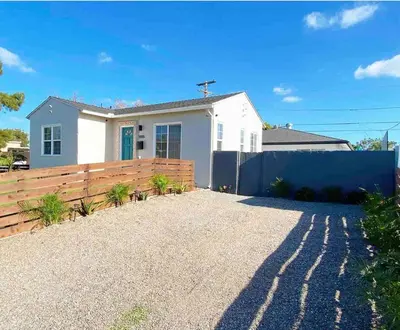a white house with a fence in front of it at Crown Point Home w/ Cowboy Pool 2 Blocks to Bay in San Diego