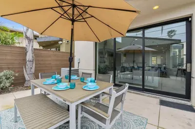 a wooden table with an umbrella on a patio at Pacific Beach Paradise by Cardo -Spacious Retreat in San Diego