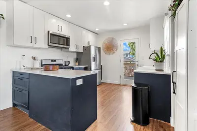 a kitchen with white cabinets and a black island at NEW Beautiful BOHO Home by Beach, Downtown + Shops in San Diego