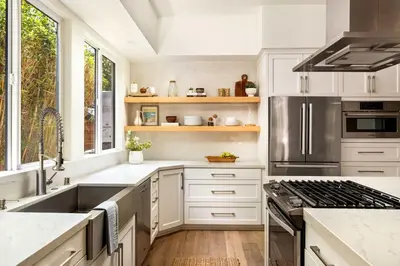 a kitchen with white cabinets and a sink and a stove at Contemporary Indoor Outdoor Living Walk to Beach in Encinitas
