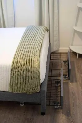 a bed with a blanket on top of a wooden floor at Pacific Beach Charm Beach and Shops Steps Away in San Diego