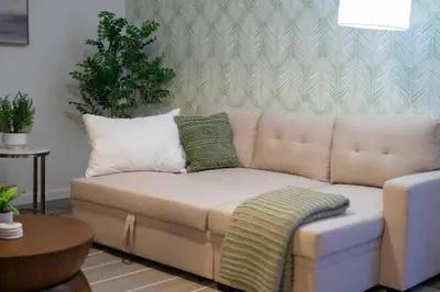 a couch sitting in a living room with a table at Pacific Beach Charm Beach and Shops Steps Away in San Diego