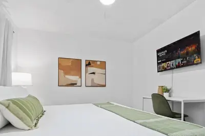 a white bedroom with a bed and a desk at Pacific Beach Charm Beach and Shops Steps Away in San Diego