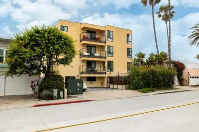 a yellow building on a street with palm trees at REDECORATED - Seaside Dream - Jacuzzi - Patio in San Diego