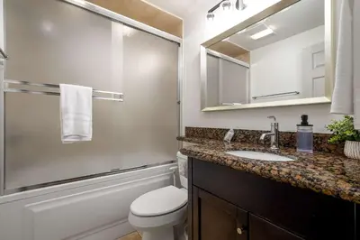 a bathroom with a toilet and a sink and a mirror at REDECORATED - Seaside Dream - Jacuzzi - Patio in San Diego