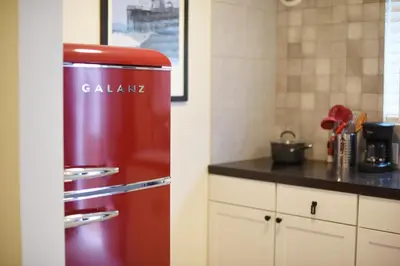 a red refrigerator in a kitchen next to a counter at Mile to Beach! Private, Family & Pet Friendly Oasis! Pool Table & Hot tub! in Oceanside