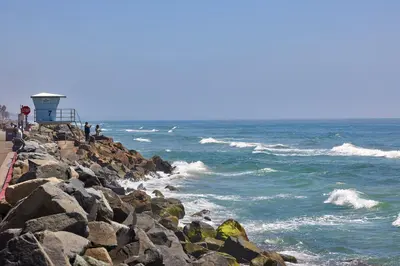 a group of people standing on the rocks near the ocean at Water Front Spectacular Ocean View Large Balcony AC Pet Friendly in Oceanside