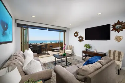 a living room with a couch and a flat screen tv at Water Front Spectacular Ocean View Large Balcony AC Pet Friendly in Oceanside