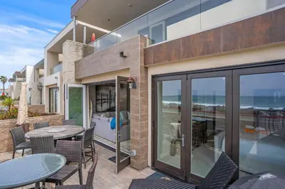 a patio with a table and chairs and the ocean at 15 Feet to the Water in Oceanside