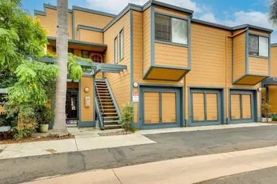 a house with a palm tree in front of it at Carlsbad Rental with Private Balcony and Pool Access! in Carlsbad