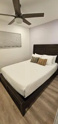 a bedroom with a large bed with a ceiling fan at Hillcrest San Diego Canyon Oasis in San Diego