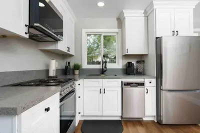 a kitchen with white cabinets and stainless steel appliances at Entire 2 Bedroom Pet Friendly Cottage Home in Alpine