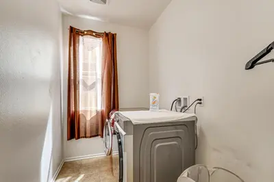 a small bathroom with a refrigerator and a window at Large Menifee Home 1 Block to Neighborhood Park! in Menifee