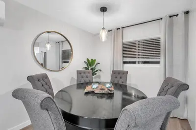 a dining room with a table and chairs and a mirror at Ultimate Oceanside Retreat | Tower 9 Across from the Beach in Oceanside