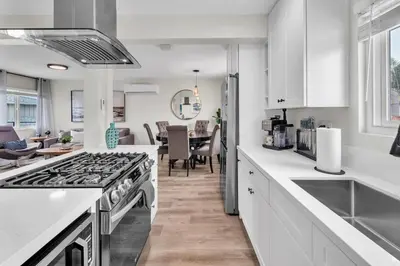 a kitchen with a stove top oven next to a dining room at Ultimate Oceanside Retreat | Tower 9 Across from the Beach in Oceanside
