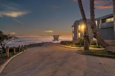 a house on a road next to the ocean at Ultimate Oceanside Retreat | Tower 9 Across from the Beach in Oceanside