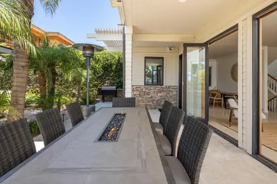 an outdoor dining room with a long table and chairs at Ocean View Del Mar Beach Home w Jacuzzi in San Diego