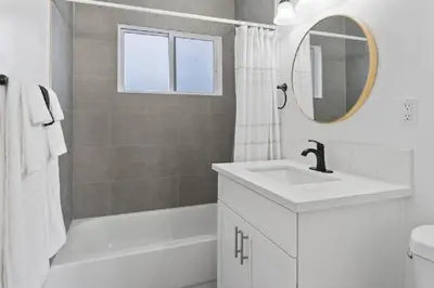 a bathroom with a sink and a tub and a mirror at Coastal Haven - Prime Spot Walk to Beach in San Diego