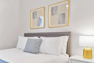 a bedroom with a white bed with two pictures on the wall at Beachside Bliss 2BR with Fast WiFi in San Diego