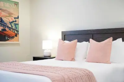 a bedroom with a large bed with pink pillows at Spacious Beach House! Walk to Beach and Pier in Oceanside
