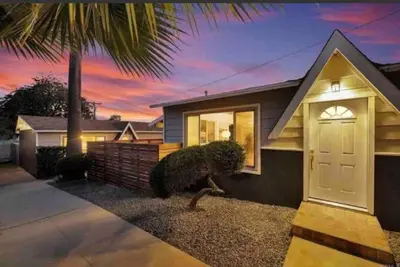 a house with a white door and a palm tree at San Diegos Best Zoo, SeaWorld and Downtown Nearby in San Diego