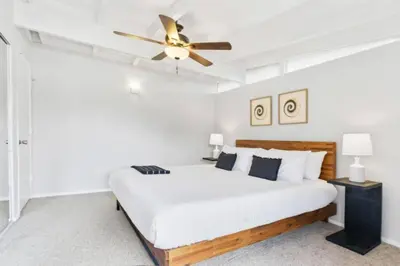 a bedroom with a bed with a ceiling fan at Relax and Play Pool, Hot Tub and Sleeps 16 in San Diego