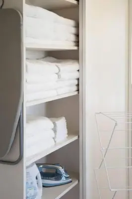 a closet filled with white towels on a shelf at Relax and Play Pool, Hot Tub and Sleeps 16 in San Diego