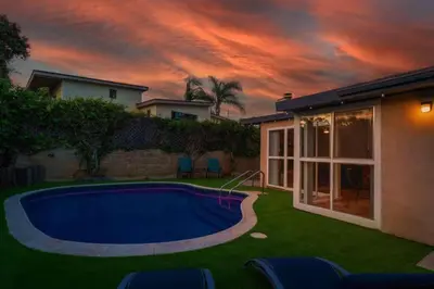 a backyard with a swimming pool and a house at Relax and Play Pool, Hot Tub and Sleeps 16 in San Diego