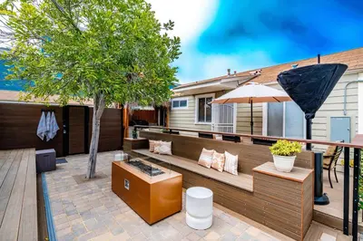 a patio with a bench and an umbrella at Pacific Beach Bungalow Just Steps to Beach in San Diego