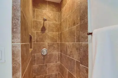 a bathroom with a shower with a brown tile at Avalon Beach 3 in San Diego