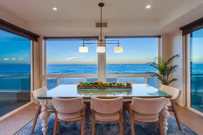 a dining room with a table and chairs and the ocean at Aloha Breeze 2 in San Diego