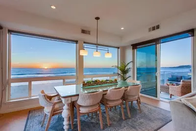 a dining room with a table and a view of the ocean at Aloha Breeze 2 in San Diego
