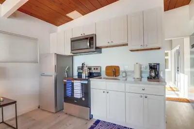 a kitchen with white cabinets and a stainless steel refrigerator at Bayside 4 in San Diego