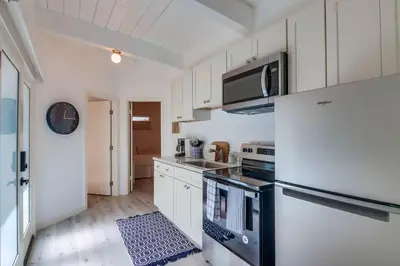 a kitchen with white cabinets and a refrigerator at Bayside 5 in San Diego
