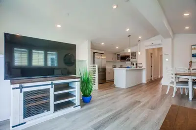 a living room with a large television and a kitchen at Bayside Cove 2 in San Diego
