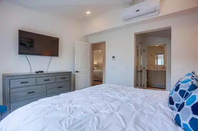 a bedroom with a white bed with a television on the wall at Bayside Cove 2 in San Diego