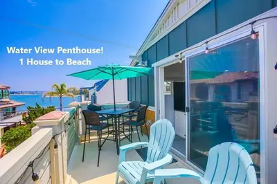 a balcony with chairs and a table with an umbrella at Bayside Cove 2 in San Diego
