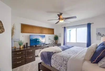a bedroom with a bed and a dresser with a television at Beach Haven 2 in San Diego