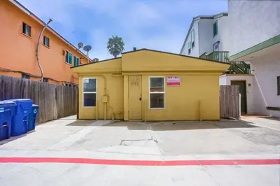 a small yellow building in a parking lot at Beach & Bay in San Diego