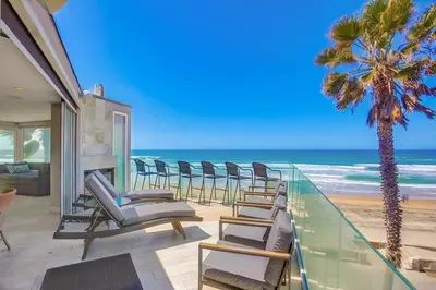 a balcony with chairs and a view of the beach at Beachside 2 in San Diego