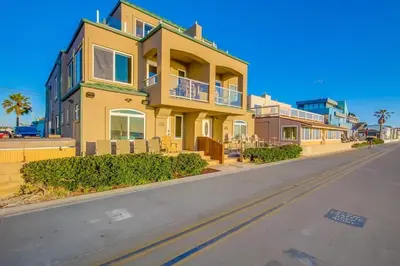 a large yellow house on the side of a street at Beach Break 2 in San Diego
