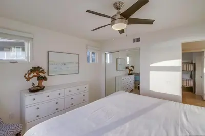 a bedroom with a white bed and a ceiling fan at Beach Break 2 in San Diego
