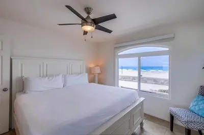 a bedroom with a bed and a window with the beach at Beach Break 2 in San Diego